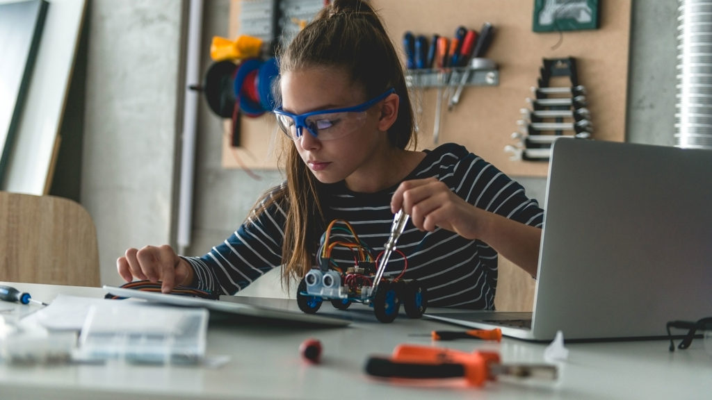 Stem Education girl working on robot at home workshop